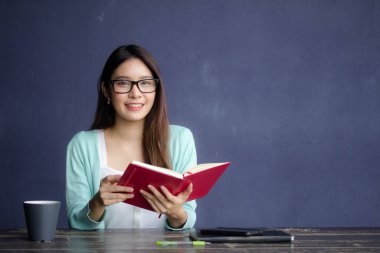 Tayland porseleni yetişkin ofis kızı gözlükleri kırmızı kitap okuyan beyaz gömlek