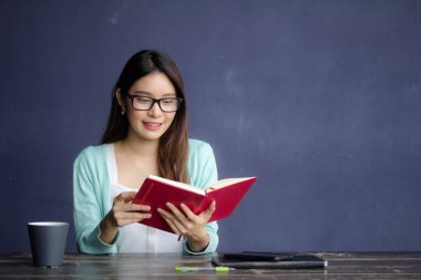 Tayland porseleni yetişkin ofis kızı gözlükleri kırmızı kitap okuyan beyaz gömlek
