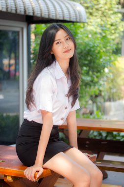 Taylandlı yetişkin öğrenci üniforması portresi. Güzel kız rahatla ve gülümse.