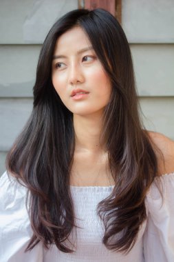 Taylandlı yetişkin güzel kız portresi. Beyaz gömlek, mavi kot pantolon, rahatla ve gülümse.