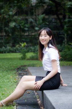 Taylandlı yetişkin öğrenci üniforması portresi. Güzel kız rahatla ve gülümse.