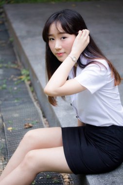 Taylandlı yetişkin öğrenci üniforması portresi. Güzel kız rahatla ve gülümse.