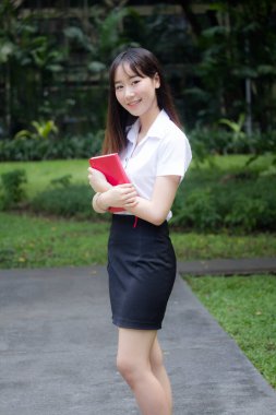 Taylandlı yetişkin öğrenci üniforması portresi. Güzel kız rahatla ve gülümse.