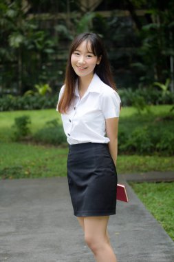 Taylandlı yetişkin öğrenci üniforması portresi. Güzel kız rahatla ve gülümse.