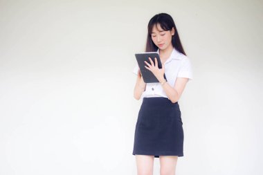 Taylandlı yetişkin öğrenci üniforması tabletini kullanan güzel bir kızın portresi..