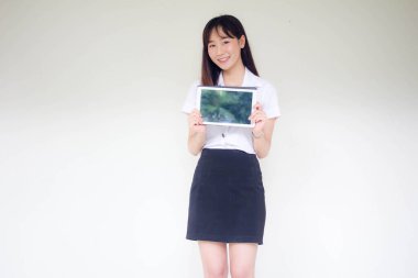 Portrait of thai adult student university uniform beautiful girl show her tablet.