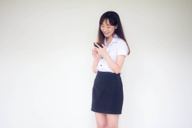 Taylandlı yetişkin öğrenci üniformasının portresi. Akıllı telefonunu kullanan güzel bir kız.