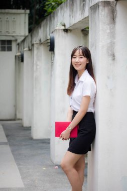 Taylandlı yetişkin öğrenci üniforması portresi. Güzel kız rahatla ve gülümse.