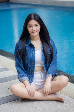 Taylandlı yetişkin portresi. Güzel kız. Havuz kenarında kot pantolon.