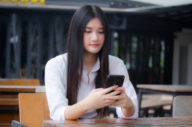 Taylandlı yetişkin ofis kızı akıllı telefonu arıyor.