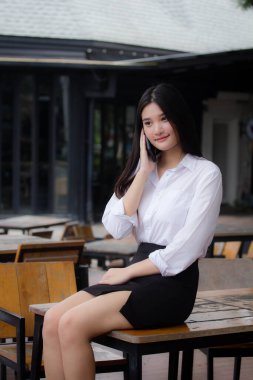 Taylandlı yetişkin ofis kızı akıllı telefonu arıyor.