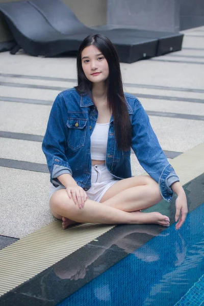 泰艾成年漂亮女孩在游泳池边的画像 蓝色牛仔裤 — 图库照片