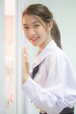 Taylandlı liseli üniformasının portresi. Genç güzel kız mutlu ve rahat.