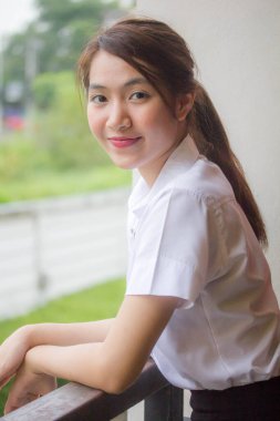 Taylandlı yetişkin öğrenci üniforması portresi. Güzel kız rahatla ve gülümse.