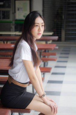 Taylandlı yetişkin öğrenci üniforması portresi. Güzel kız rahatla ve gülümse.