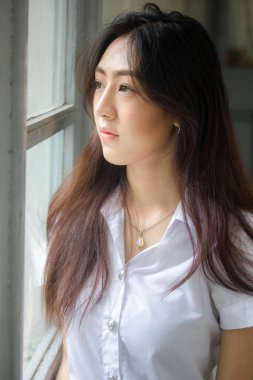 Taylandlı yetişkin öğrenci üniforması portresi. Güzel kız rahatla ve gülümse.