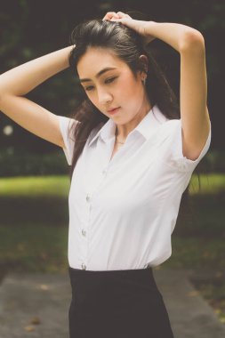 Taylandlı yetişkin öğrenci üniforması portresi. Güzel kız rahatla ve gülümse.