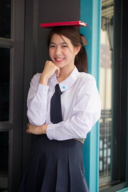 Taylandlı liseli üniformasının portresi. Genç güzel kız mutlu ve rahat.