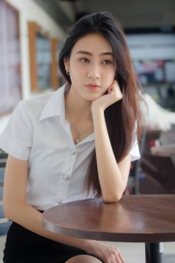 Taylandlı yetişkin öğrenci üniforması portresi. Güzel kız rahatla ve gülümse.