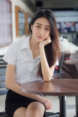 Taylandlı yetişkin öğrenci üniforması portresi. Güzel kız rahatla ve gülümse.