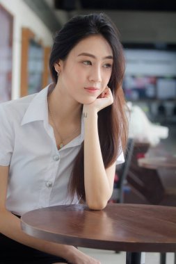 Taylandlı yetişkin öğrenci üniforması portresi. Güzel kız rahatla ve gülümse.