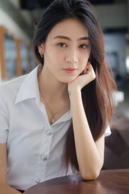 Taylandlı yetişkin öğrenci üniforması portresi. Güzel kız rahatla ve gülümse.