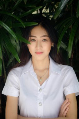 Taylandlı yetişkin öğrenci üniforması portresi. Güzel kız rahatla ve gülümse.