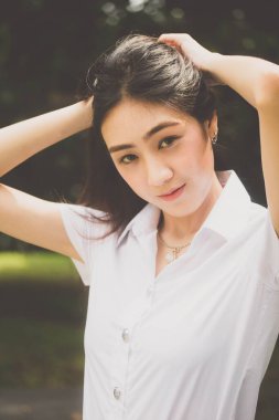 Taylandlı yetişkin öğrenci üniforması portresi. Güzel kız rahatla ve gülümse.