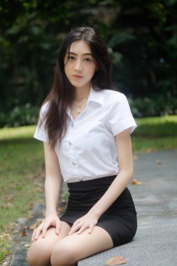 Taylandlı yetişkin öğrenci üniforması portresi. Güzel kız rahatla ve gülümse.