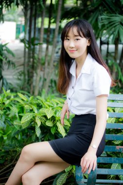 Taylandlı yetişkin öğrenci üniforması portresi. Güzel kız rahatla ve gülümse.