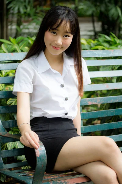 Taylandlı yetişkin öğrenci üniforması portresi. Güzel kız rahatla ve gülümse.