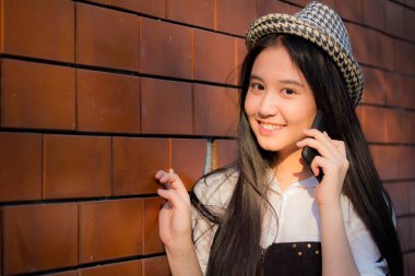 Taylandlı genç kızın portresi. Güzel kız, akıllı telefonu arıyor.