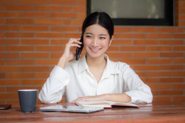 Tayland porseleni yetişkin ofis kızı beyaz gömlek kırmızı etek akıllı telefonu arıyor