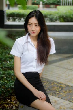 Taylandlı yetişkin öğrenci üniforması portresi. Güzel kız rahatla ve gülümse.