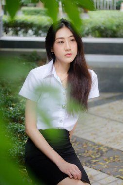 Taylandlı yetişkin öğrenci üniforması portresi. Güzel kız rahatla ve gülümse.