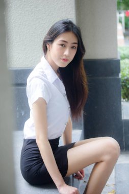 Taylandlı yetişkin öğrenci üniforması portresi. Güzel kız rahatla ve gülümse.