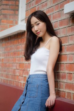 Tayland portresi yetişkin güzel kız beyaz gömlek mavi kot rahatla ve gülümse