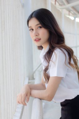 Taylandlı yetişkin öğrenci üniforması portresi. Güzel kız rahatla ve gülümse.