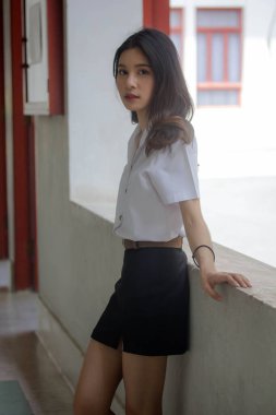 Taylandlı yetişkin öğrenci üniforması portresi. Güzel kız rahatla ve gülümse.