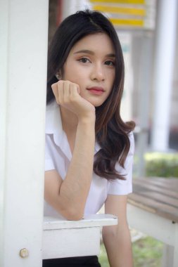 Taylandlı yetişkin öğrenci üniforması portresi. Güzel kız rahatla ve gülümse.