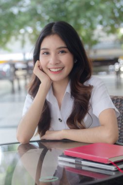 Taylandlı yetişkin öğrenci üniforması portresi. Güzel kız rahatla ve gülümse.