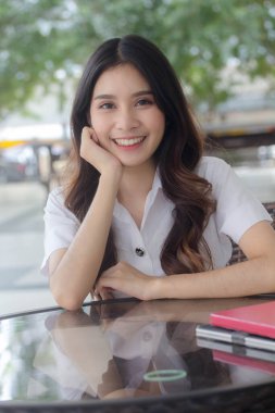 Taylandlı yetişkin öğrenci üniforması portresi. Güzel kız rahatla ve gülümse.