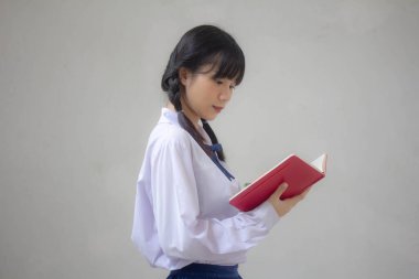 Asya Thai Lisesi üniformalı güzel kız. Bir kitap yaz.