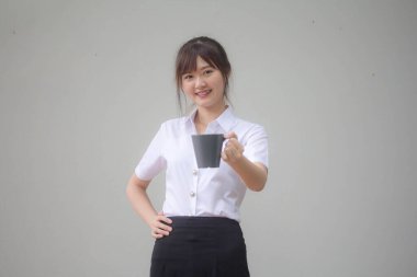 Taylandlı yetişkin öğrenci üniformasının portresi. Güzel kahve içiyor.