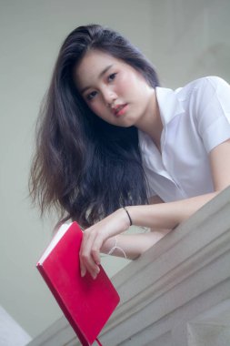 Taylandlı yetişkin öğrenci üniforması güzel kız rahatla ve gülümse.