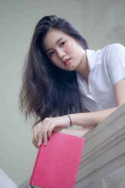 Taylandlı yetişkin öğrenci üniforması güzel kız rahatla ve gülümse.