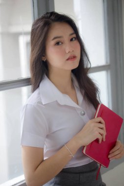 Taylandlı yetişkin öğrenci üniforması güzel kız rahatla ve gülümse.