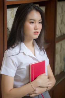 Taylandlı yetişkin öğrenci üniforması güzel kız rahatla ve gülümse.