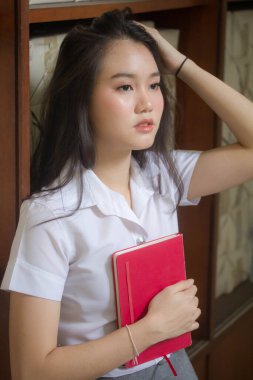 Taylandlı yetişkin öğrenci üniforması güzel kız rahatla ve gülümse.