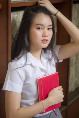 Taylandlı yetişkin öğrenci üniforması güzel kız rahatla ve gülümse.